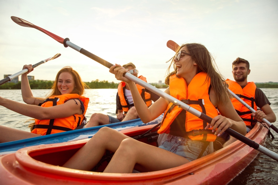 happy-friends-kayaking-river-with-sunset-background-min