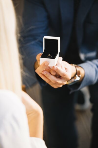 male-hands-with-red-velvet-box-containing-engagement-ring-min